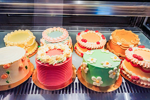 colorful assortment of decorative cakes displayed in a glass case